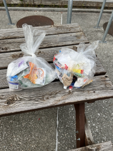 Two small clear trash bags with various wrappers